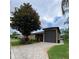 Inviting home exterior featuring a paved driveway, green lawn, and mature trees at 1167 Motorcoach Dr, Polk City, FL 33868