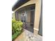 Close-up of the front porch with a screen door, stone walkway, and lush plantings at 1167 Motorcoach Dr, Polk City, FL 33868