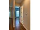 Hallway featuring wood floors leading to a bedroom with blue walls and an adjacent bathroom at 1167 Motorcoach Dr, Polk City, FL 33868