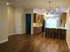 Spacious living space flowing into the kitchen, featuring modern lighting and wood-look floors at 1167 Motorcoach Dr, Polk City, FL 33868