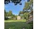 Backyard featuring lush lawn, established trees, and a storage shed, providing a private outdoor setting at 1215 E Edgewood Dr, Lakeland, FL 33803