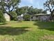Spacious backyard featuring lush lawn, storage shed, and mature trees offering ample shade at 1215 E Edgewood Dr, Lakeland, FL 33803