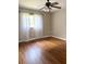 Bedroom features hardwood floors, a ceiling fan, and bright natural light from the large window at 1215 E Edgewood Dr, Lakeland, FL 33803