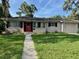 Inviting single-story home with a bright red door, neat landscaping, and an attached garage, creating great curb appeal at 1215 E Edgewood Dr, Lakeland, FL 33803