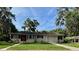 Charming single-story home featuring a red front door, well-maintained lawn, and an attached one-car garage at 1215 E Edgewood Dr, Lakeland, FL 33803