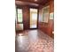 Charming sun room featuring wood paneling, unique tile floors, and windows, offering a bright and inviting space at 1215 E Edgewood Dr, Lakeland, FL 33803