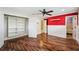 Bedroom boasts hardwood floors, closet, and decorative red accent wall at 1235 Lake Point Dr, Lakeland, FL 33813