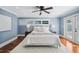 Bedroom featuring blue walls, hardwood floors, a ceiling fan, and doors leading to an outdoor area at 1235 Lake Point Dr, Lakeland, FL 33813