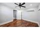 Bedroom featuring hardwood floors, a ceiling fan, and built-in closet shelving at 1235 Lake Point Dr, Lakeland, FL 33813