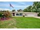 Well-maintained home with a lush green lawn and manicured landscaping around the front at 1235 Lake Point Dr, Lakeland, FL 33813