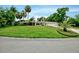 Well-manicured front lawn with tropical plants and a brick paver driveway at 1235 Lake Point Dr, Lakeland, FL 33813