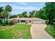 Beautiful single-story home with a well-manicured lawn, brick driveway, and lush tropical landscaping at 1235 Lake Point Dr, Lakeland, FL 33813