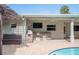 Outdoor kitchen with a grill and counter space, a built-in bench, and a pergola provide ample space for backyard entertainment at 1235 Lake Point Dr, Lakeland, FL 33813