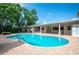 Backyard swimming pool with a brick patio, outdoor kitchen, and covered lounge area, great for entertaining at 1235 Lake Point Dr, Lakeland, FL 33813