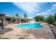 Paver patio backyard with a pool, outdoor kitchen, and lush green landscaping, perfect for relaxation and entertaining at 1235 Lake Point Dr, Lakeland, FL 33813