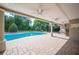 Covered patio overlooking the pool and backyard that includes an outdoor kitchen and landscaped yard, perfect for entertaining at 1235 Lake Point Dr, Lakeland, FL 33813
