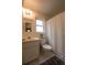 Functional bathroom features a standard sink, toilet, and shower with white tile flooring at 1410 Bramblewood Dr, Lakeland, FL 33811