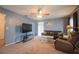 Comfortable living room featuring soft carpet, a leather sofa, and modern entertainment center at 1410 Bramblewood Dr, Lakeland, FL 33811