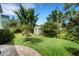 Beautiful backyard featuring lush green grass, mature trees, and a charming storage shed at 1825 Pawnee Trl, Lakeland, FL 33803