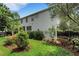View of the home's backyard featuring lush landscaping, green grass and a backup generator at 1825 Pawnee Trl, Lakeland, FL 33803
