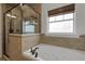 Bathroom with a garden tub, decorative tile, and a window that allows for natural light at 1825 Pawnee Trl, Lakeland, FL 33803