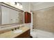 Bathroom featuring granite counters, tile backsplash, and a shower-tub combination at 1825 Pawnee Trl, Lakeland, FL 33803