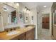 Double vanity bathroom with granite countertops, decorative mirrors, and a door to the closet at 1825 Pawnee Trl, Lakeland, FL 33803