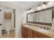 Bathroom with double sink vanity, granite counters, and large mirror, plus a door to a shower and commode at 1825 Pawnee Trl, Lakeland, FL 33803