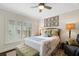 Cozy bedroom featuring a ceiling fan, area rug, upholstered bench, and shuttered window at 1825 Pawnee Trl, Lakeland, FL 33803