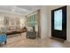 Inviting foyer featuring decorative door, stylish chair, and view of living room with abundant natural light at 1825 Pawnee Trl, Lakeland, FL 33803