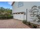 Image of a two car garage with paneled doors and brick paver driveway at 1825 Pawnee Trl, Lakeland, FL 33803