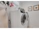 Laundry room features a large white washer and dryer, overhead rack, and decorative wall art at 1825 Pawnee Trl, Lakeland, FL 33803