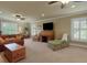 Spacious living room featuring multiple windows, sofas, ceiling fans, and a wooden rolltop desk at 1825 Pawnee Trl, Lakeland, FL 33803