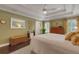 A cozy main bedroom with a ceiling fan, neutral decor, a sitting area, and natural light from the windows at 1825 Pawnee Trl, Lakeland, FL 33803