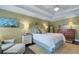 Comfortable main bedroom featuring a bed with decorative pillows, a ceiling fan, and a wooden dresser at 1825 Pawnee Trl, Lakeland, FL 33803