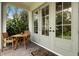 Covered patio with outdoor seating, French doors, and a view of the lush backyard at 1825 Pawnee Trl, Lakeland, FL 33803
