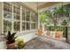 Inviting front porch with a porch swing, stone pillars, and lush landscaping at 1825 Pawnee Trl, Lakeland, FL 33803