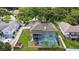 Aerial view of a home showcasing a screened-in pool, backyard, and well-maintained landscaping in a residential neighborhood at 1922 Matthew Ct, Lakeland, FL 33813
