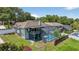 Aerial view of a home with a large screened-in pool, backyard patio, and mature trees at 1922 Matthew Ct, Lakeland, FL 33813