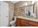 Bathroom highlighting a granite countertop vanity, toilet, and a large mirror at 1922 Matthew Ct, Lakeland, FL 33813