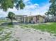 A view of the backyard with an attached carport and a yellow house ready to be renovated at 2120 Dille St, Lakeland, FL 33815