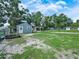 The backyard features a large storage shed and mature trees throughout the property at 2120 Dille St, Lakeland, FL 33815