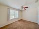 This bedroom has a ceiling fan, large window, and neutral walls at 222 Carpenters Way # 65, Lakeland, FL 33805
