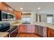 Kitchen featuring stainless steel appliances, wood cabinets, and a view of the adjacent living area at 222 Carpenters Way # 65, Lakeland, FL 33805