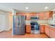 A well-lit kitchen with stainless steel appliances and wood cabinets at 222 Carpenters Way # 65, Lakeland, FL 33805