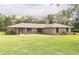 Charming single story brick home with a well-manicured lawn, complimented by lush trees and greenery at 2331 D R Bryant Rd, Lakeland, FL 33810