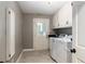 Functional laundry room with white cabinets, tile floors, and a sink at 2331 D R Bryant Rd, Lakeland, FL 33810