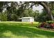 Spacious outbuilding with roll-up door on a expansive lawn, perfect for storage and other uses at 2331 D R Bryant Rd, Lakeland, FL 33810