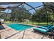 Sparkling pool with a screened-in enclosure, surrounded by lounge chairs, and a lush green yard at 2331 D R Bryant Rd, Lakeland, FL 33810