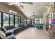 Bright sunroom with tile flooring, ceiling fans, large windows and a gray sectional couch for relaxing and entertaining at 2331 D R Bryant Rd, Lakeland, FL 33810